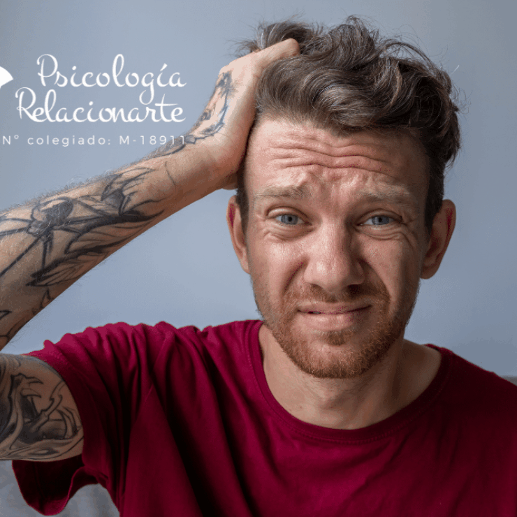 Un hombre con camiseta roja y tatuajes en el brazo llevándose la mano a la cabeza por un Un hombre con camiseta roja y tatuajes en el brazo llevándose la mano a la cabezaUn hombre con camiseta roja y tatuajes en el brazo llevándose la mano a la cabeza por un diagnóstico tardío de tdah en adultos