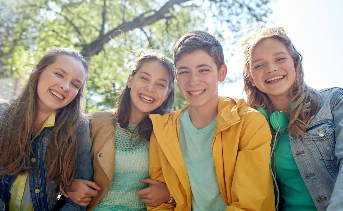grupo de adolescentes agarrados por el brazo sonriendo con las competencias emocionales en la adolescencia