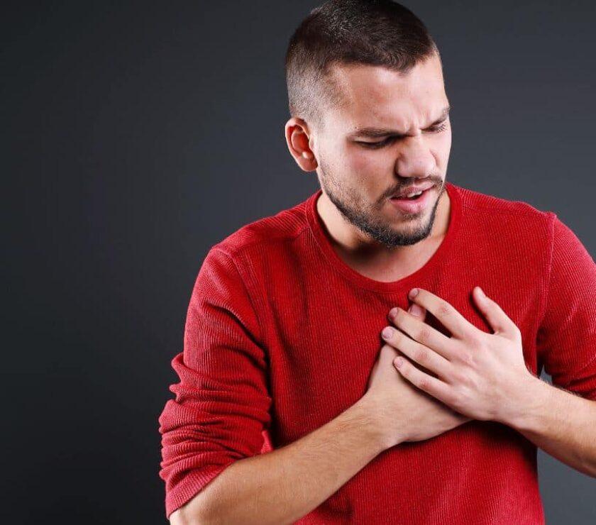 Hombre joven llevándose las manos al pecho temiendo un infarto por ansiedad