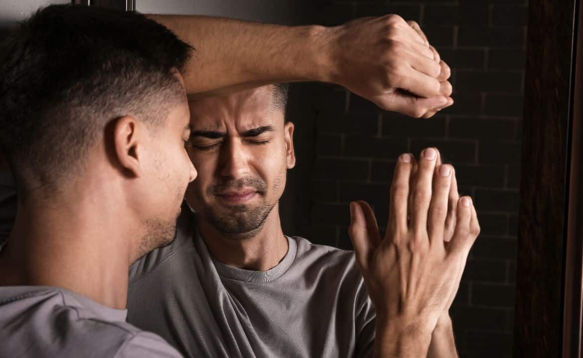 Manos empujando contra sí mismas en un espejo para mejorar la resiliencia y psicología