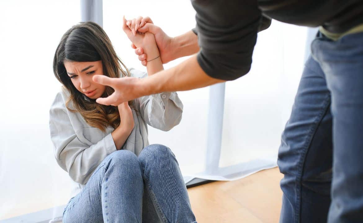mujer joven agarrada y atemorizada por un hombre a falta de prevenir la violencia de género