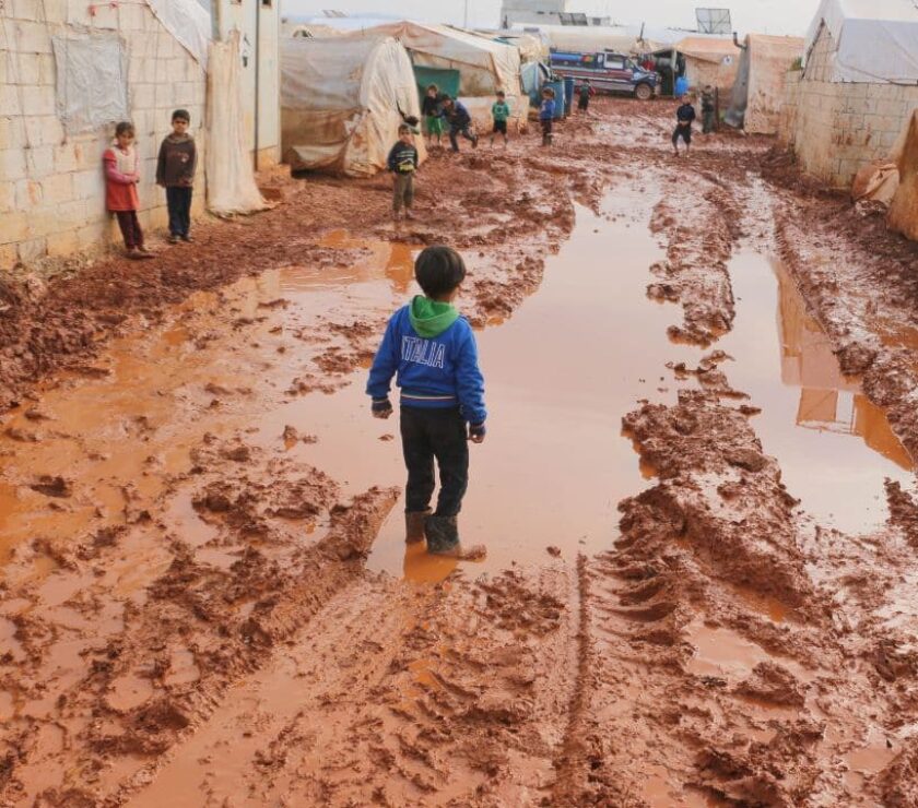 niños jugando en calle embarrada y encharcada esperando al psicólogo en intervención social