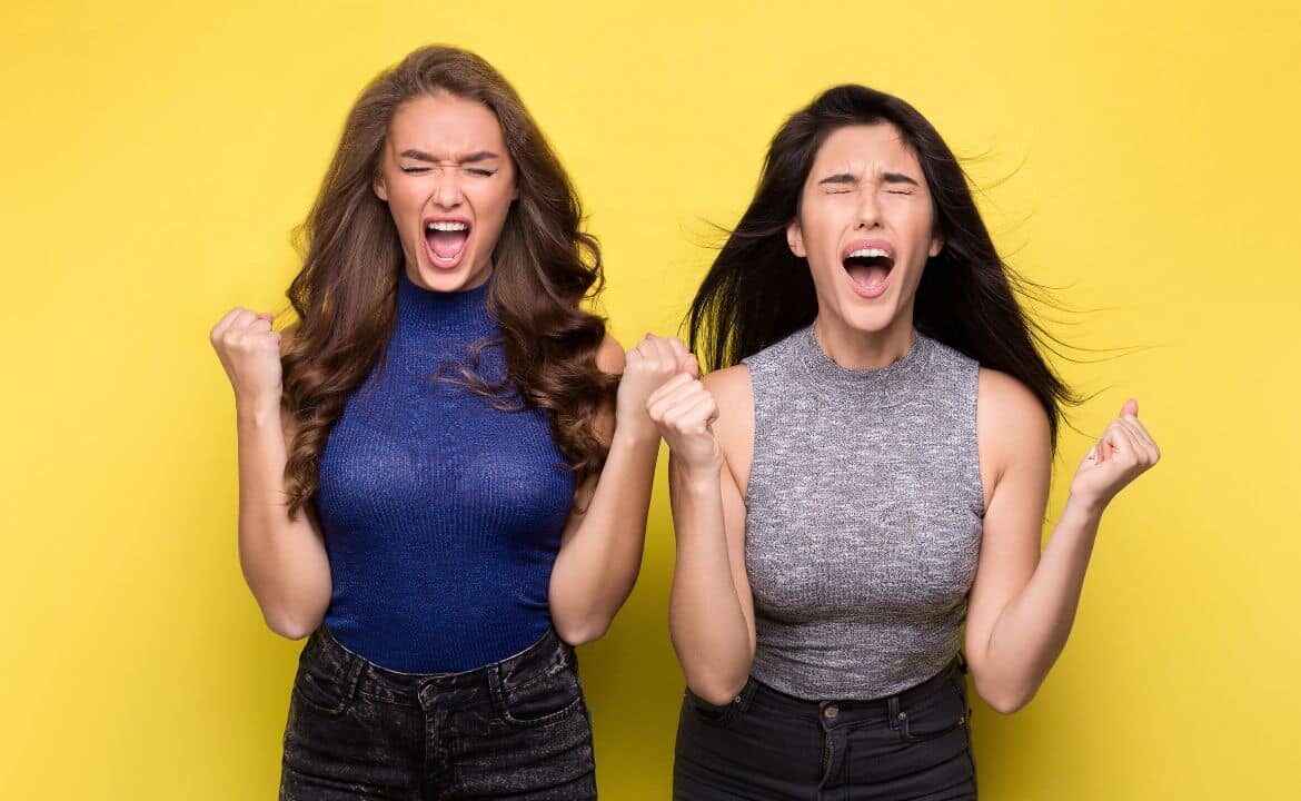 dos mujeres jóvenes con melena gritando con los puños cerrados manifestando rasgos del trastorno histriónico de la personalidad