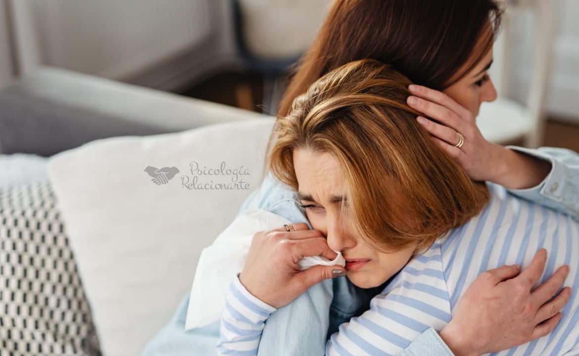 Una mujer calmando a otra en un abrazo para cuidarse y cuidar su bienestar emocional.