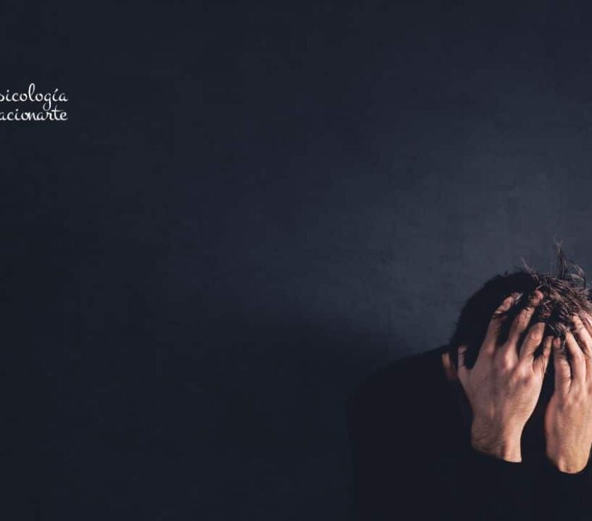 Hombre con jersey negro agachado con las manos en la cabeza viviendo la experiencia de pérdida y el duelo