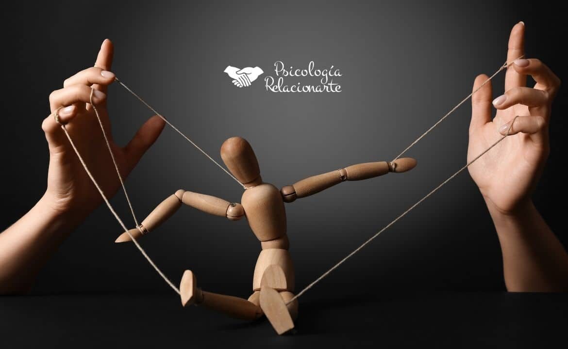 Manos de una persona manipuladora manejando los hilos que controlan a una marioneta que representa cómo el control emocional convierte a quien manipula en su primer títere y prisionera de sus propias estrategias.