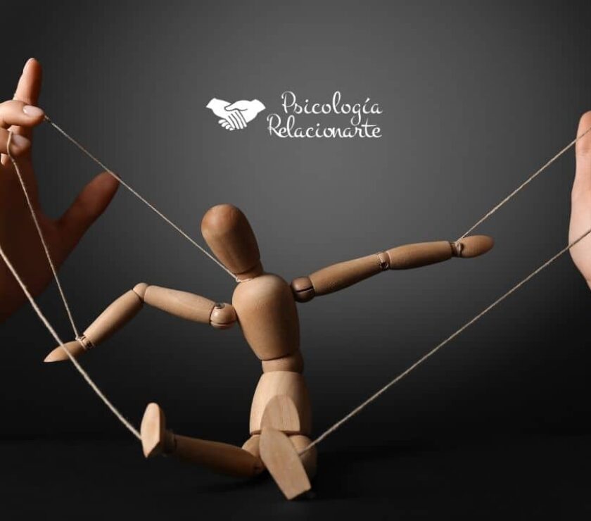 Manos de una persona manipuladora manejando los hilos que controlan a una marioneta que representa cómo el control emocional convierte a quien manipula en su primer títere y prisionera de sus propias estrategias.