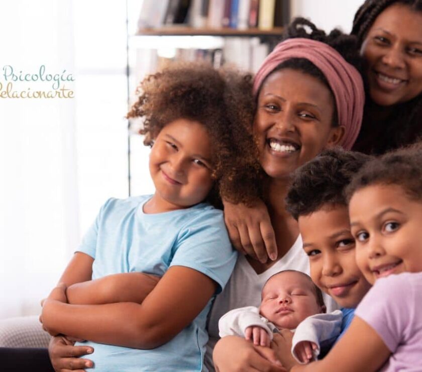 Familia con dos madres y cuatro hijos compartiendo un momento de convivencia familiar en casa