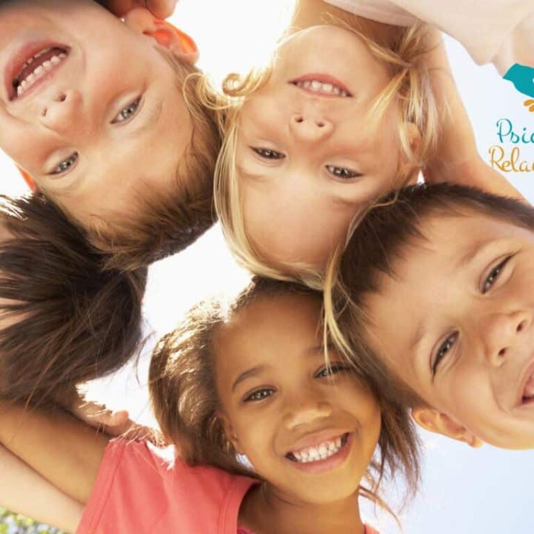 Psicólogo en Pozuelo - Psicología Relacionarte Grupo de niños con sus cabezas juntas formando un círculo sonriendo reflejando la relación entre infancia y amigos